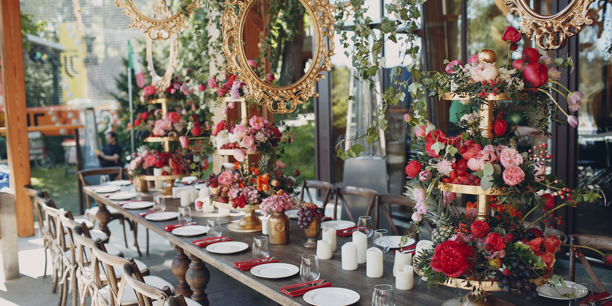 Wedding table flowers with fruits and berries decor in red white pink green colors.
